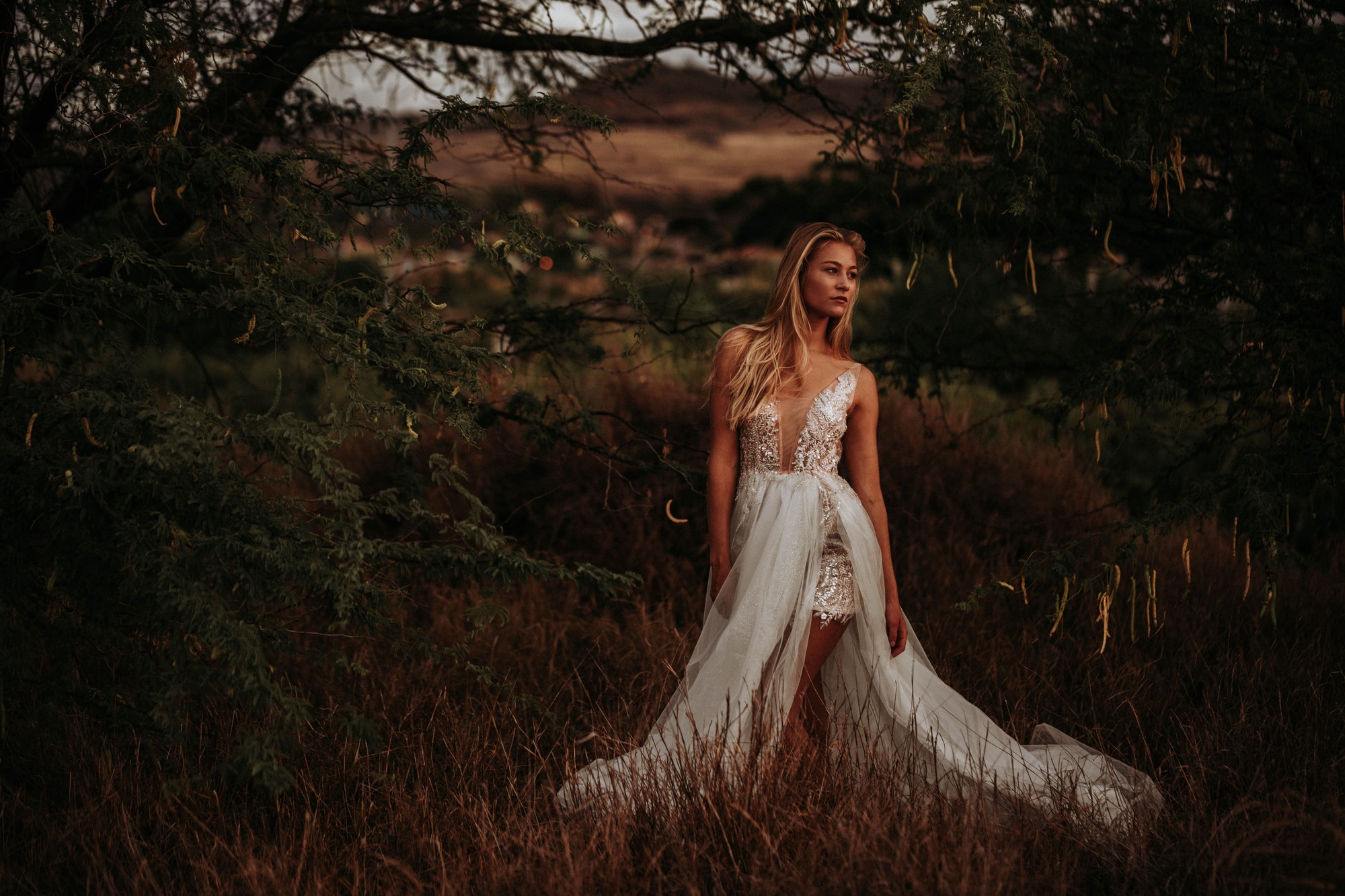 standing in nature in a gorgeous wedding dress