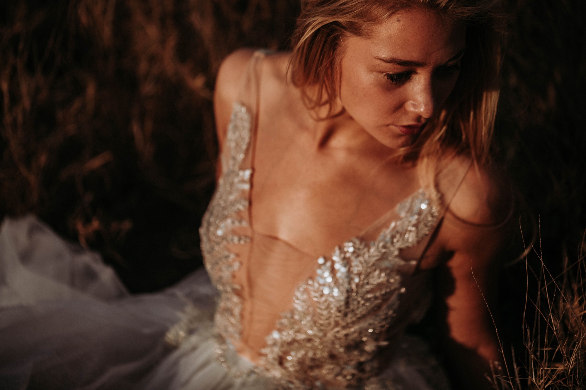blond model sitting in the summer light with a wedding dress